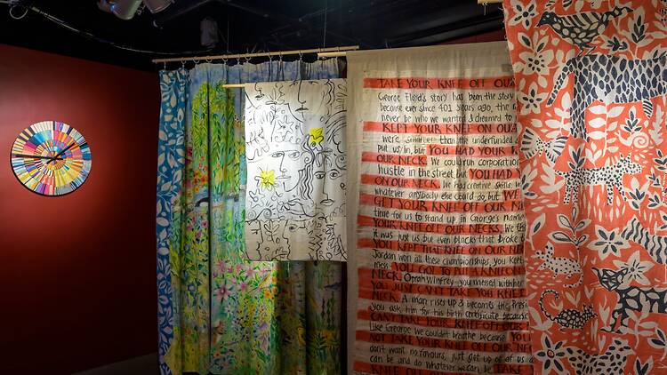 Hand-painted textiles hanging against a wall