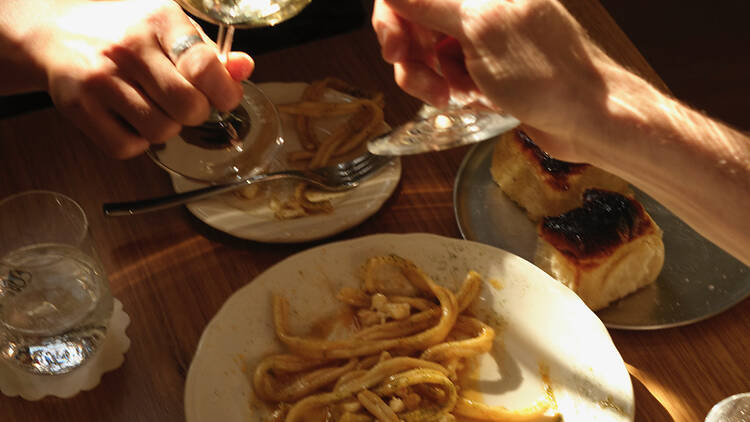 Wine glasses and a bowl of pasta.