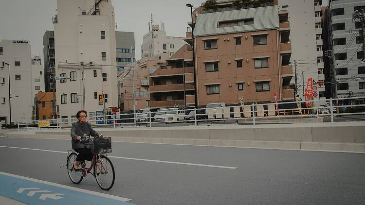 Woman riding against traffic outside the bike lane