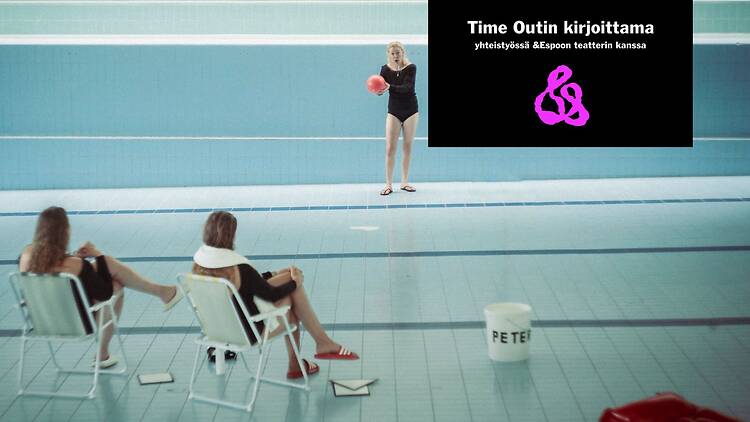 Teatteriesitys tyhjällä uima-altaalla, jossa esiintyjä seisoo punaisen pallon kanssa ja kaksi henkilöä istuu tuoleilla altaan pohjalla.
