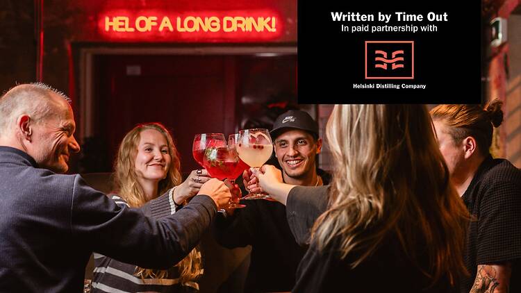 A group of friends clink glasses at the Helsinki Distillery bar