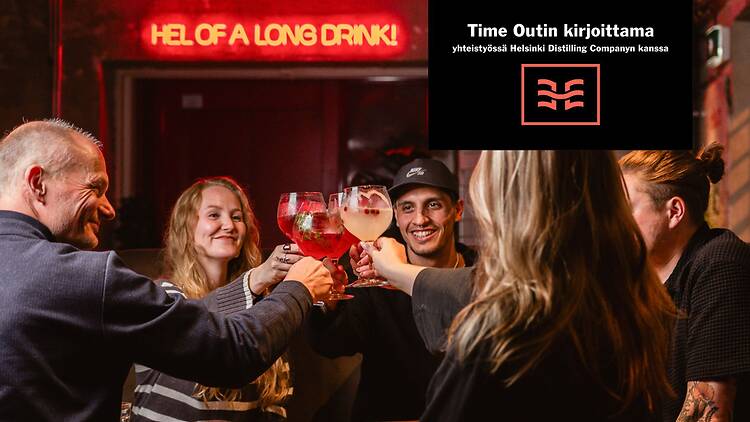 Ryhmä ystäviä skoolaa juomalaseilla Helsinki Distilleryn baarissa.