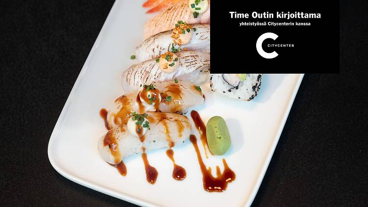 Sushi valikoima valkoisella lautasella, mukana nigiri susheja ja maki rullia