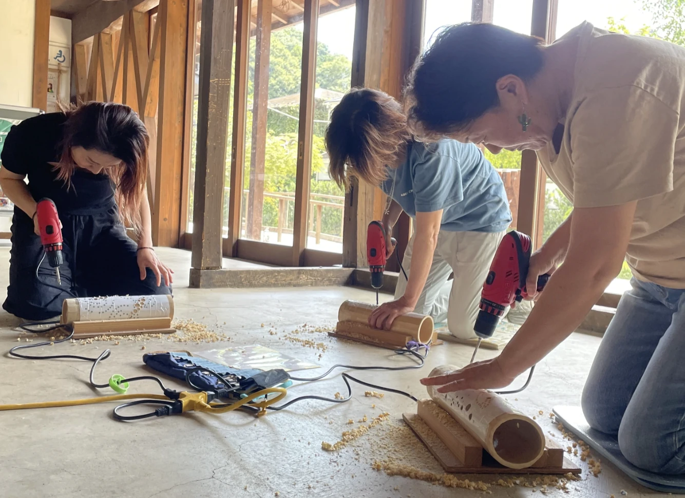 Workshop participants drilling a bamboo lantern