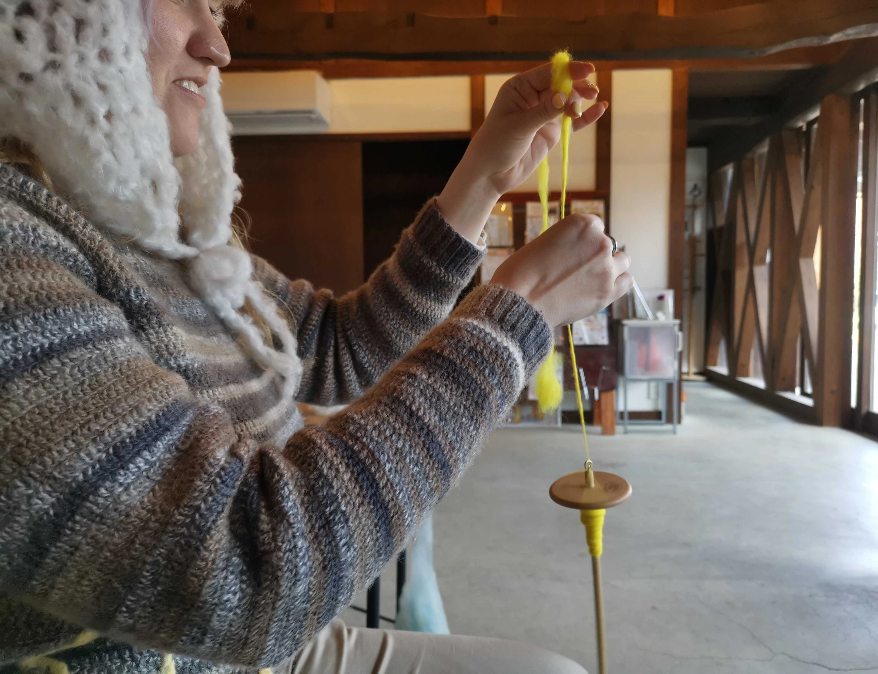 Tour participant using drop spindle