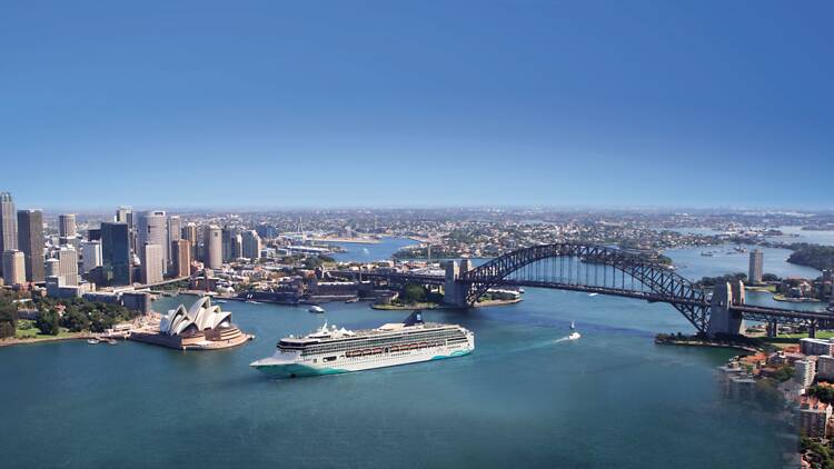 A cruise ship sailing past Syd Opera House and Bridge
