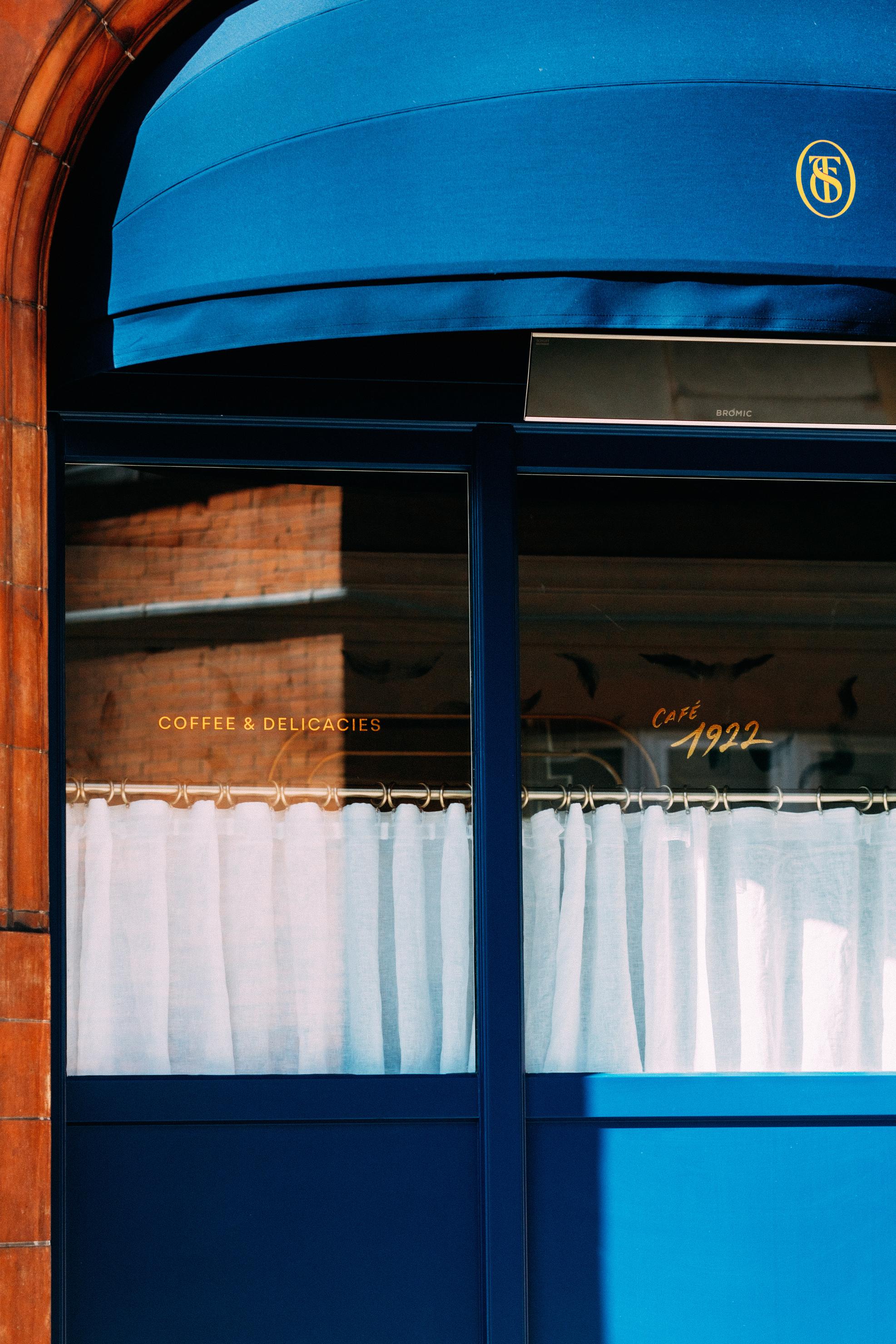 Window and blue awning of The Sloane Club's new Cafe 1922 space
