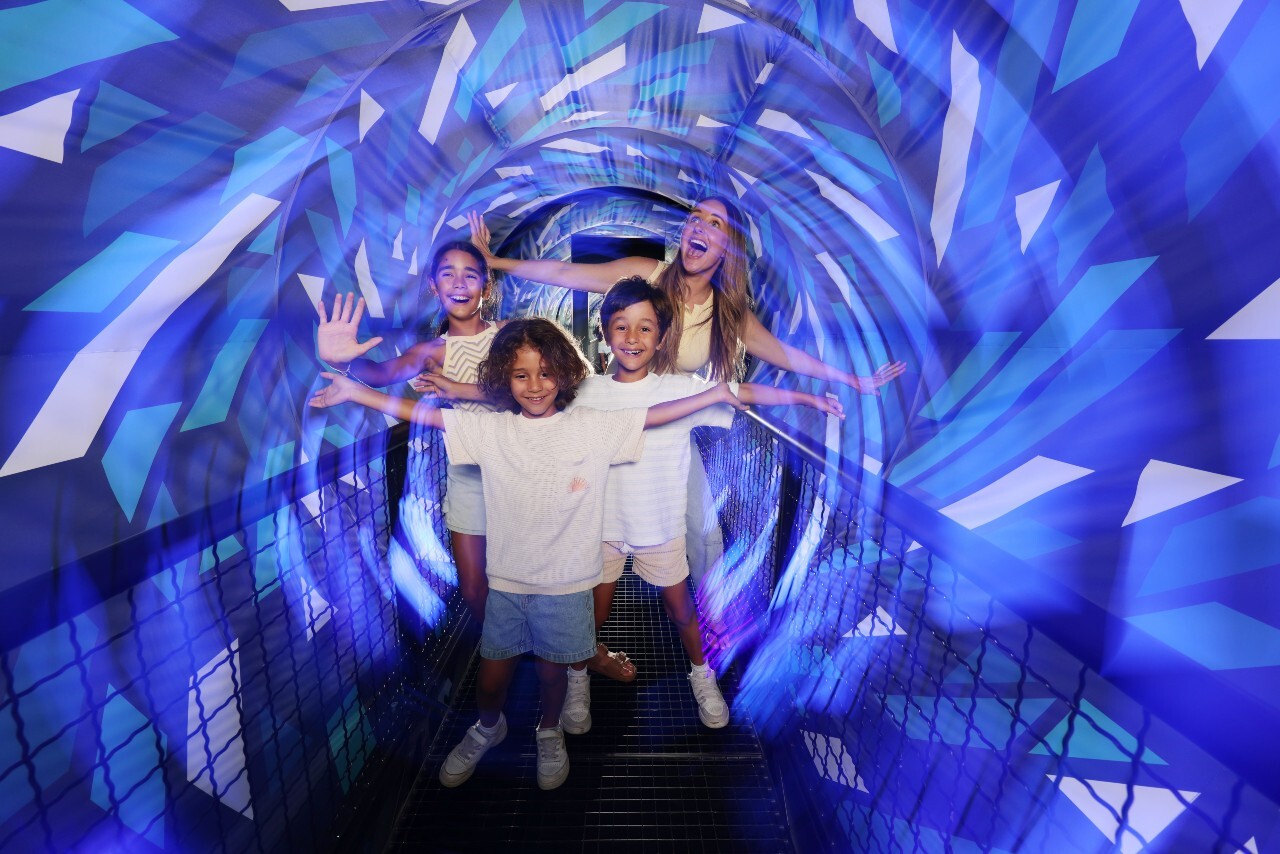 Four people navigating through a swirling tunnel