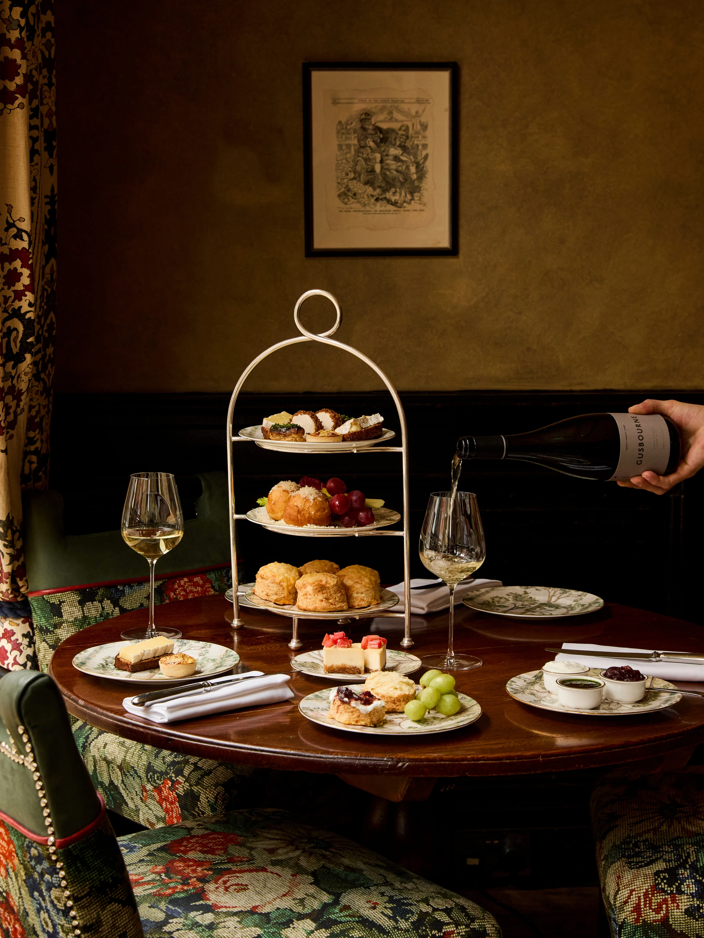 Afternoon tea set up with rack of plates and glasses of wine