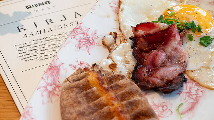 Karjalanpiirakka, pekonia ja paistettu kananmuna aamiaisella