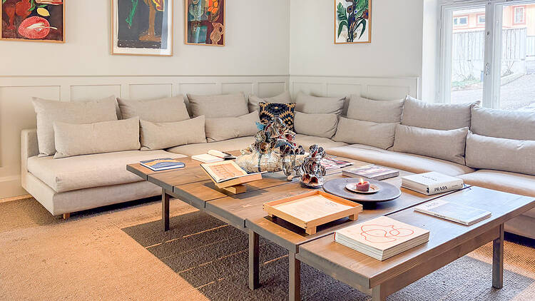 Hotelli Runon aulassa on iso sohva ja puupöytä jolla on taidekirjoja