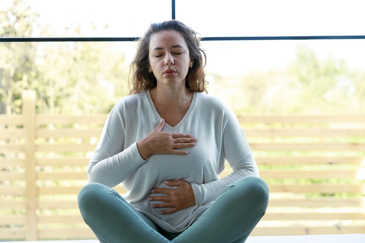 Front view of a relaxed woman doing breathing exercise at home