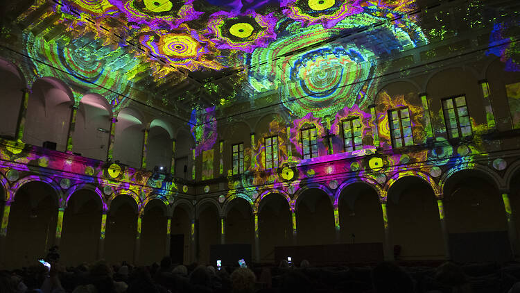 Eonarium Enlightenment A large room illuminated by colourful projections.