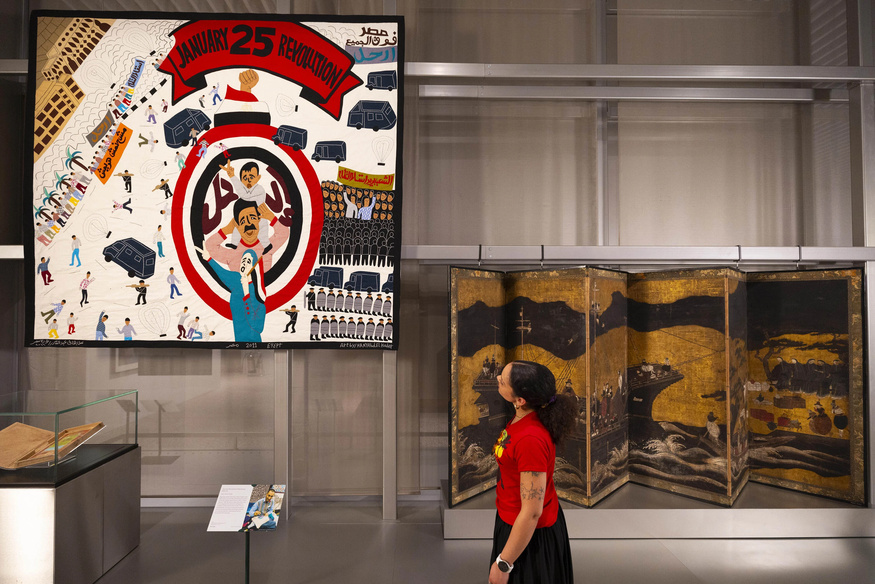 An Egyptian revolutionary textile displayed next to a Japanese screen