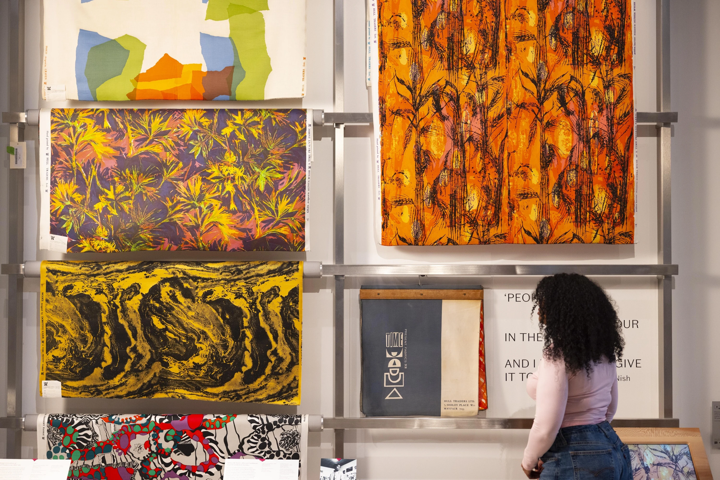 Woman looking at colourful marbled paper designs in the V&A East