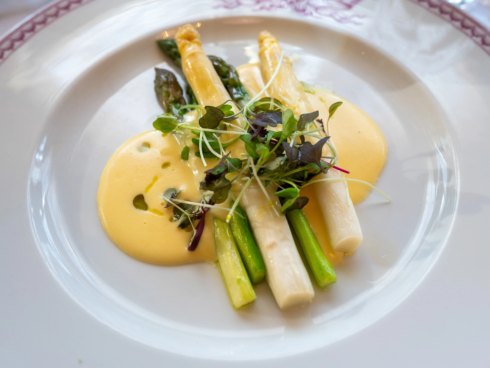 Valkoista ja vihre&auml;&auml; parsaa lautasella bearnaise-kastikkeessa