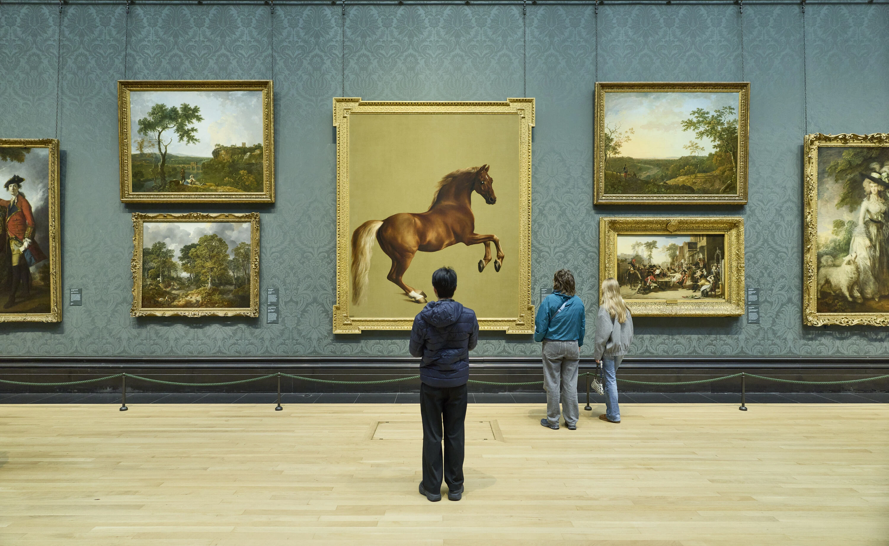 Visitors look at famous horse painting in The National Gallery, London