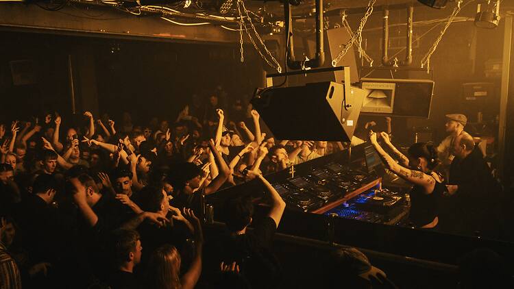 A full crowd raising their arms in the air in Phonox nightclub