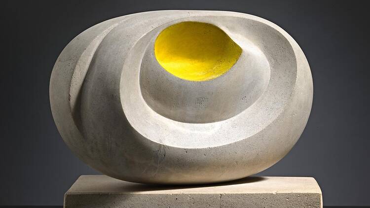 White oval-shaped sculpture with yellow detail in the centre 