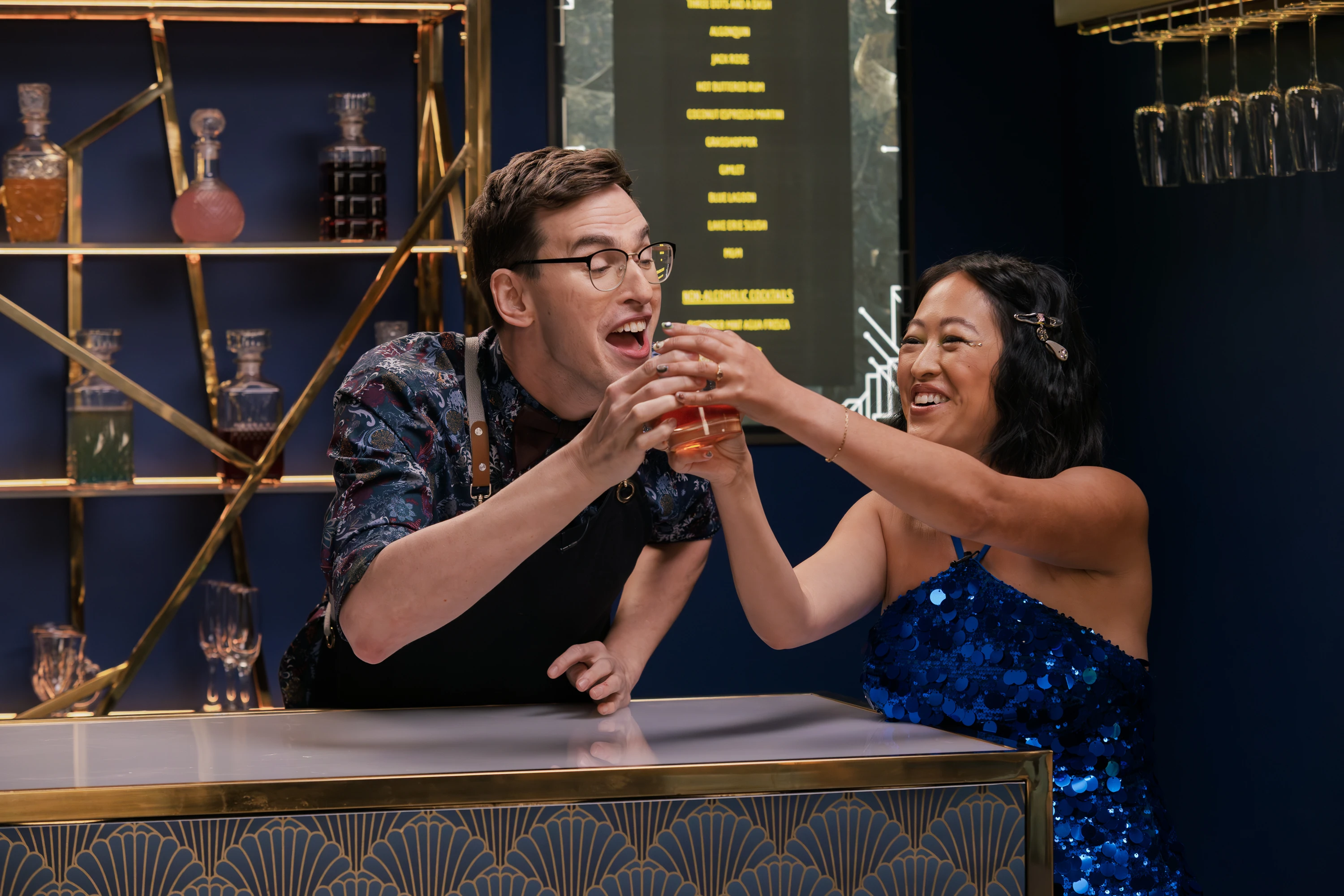 Two stars of Dirty Laundry comedy show wrestling over a drink and laughing