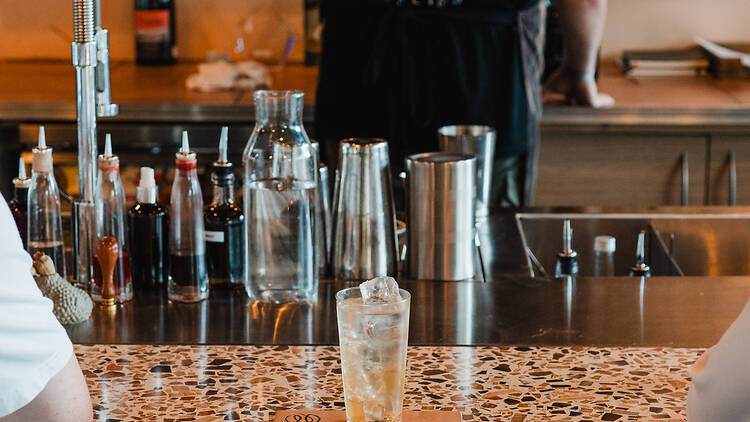 Cocktail on bar in front of mixology equipment