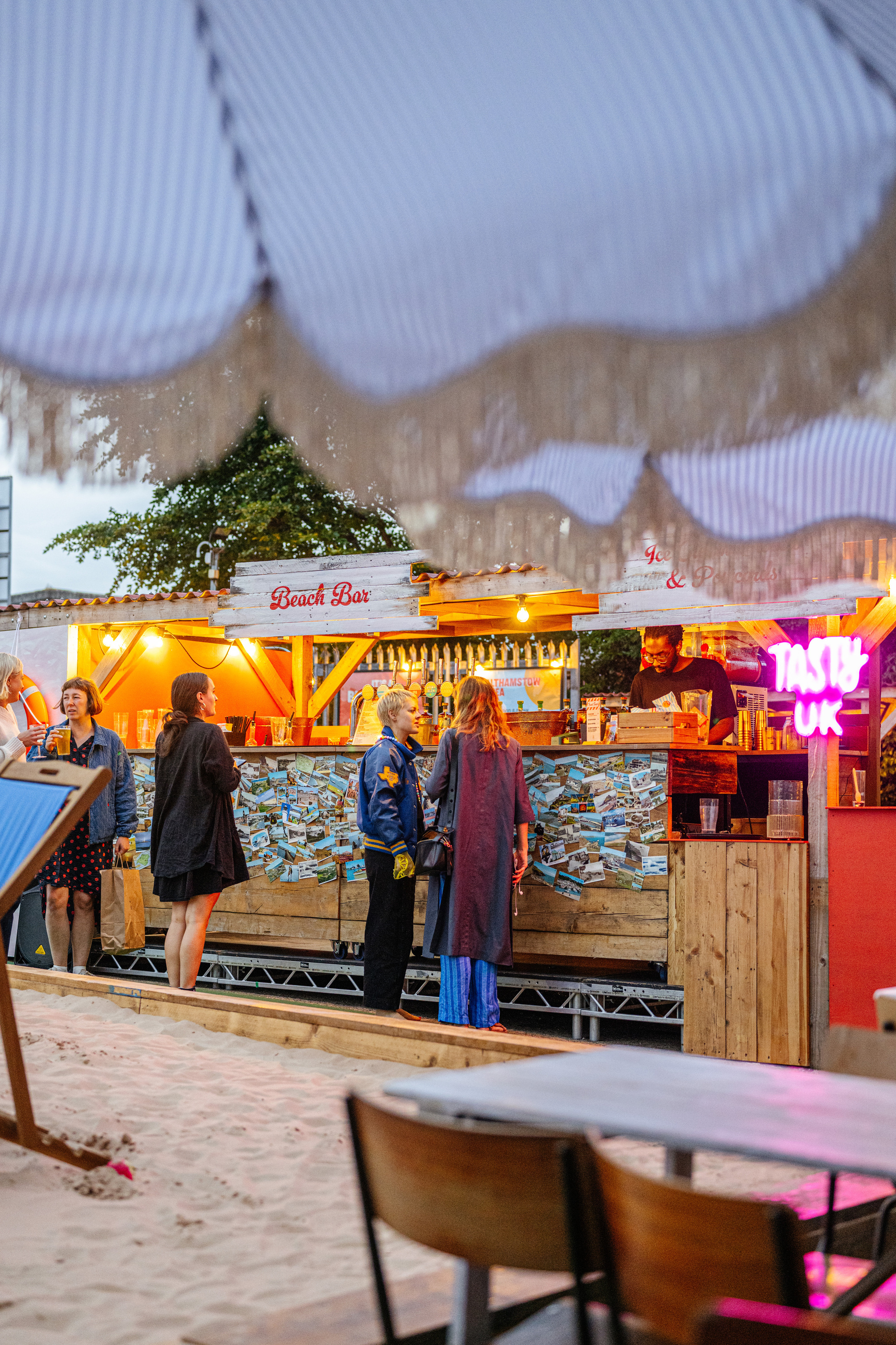 Fake beach surrounded by food and drink stalls outside 