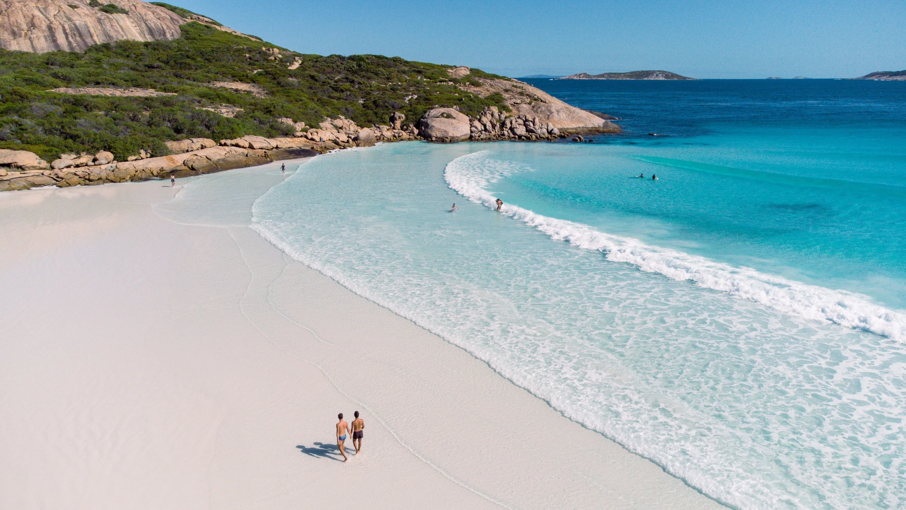 Beach with couple walking on it