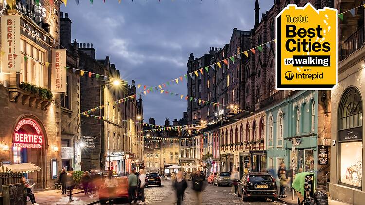 People walking along a street in Edinburgh at night