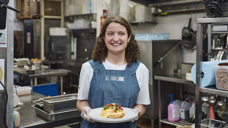 A person holding a plate of food in the All Things Equal kitchen.