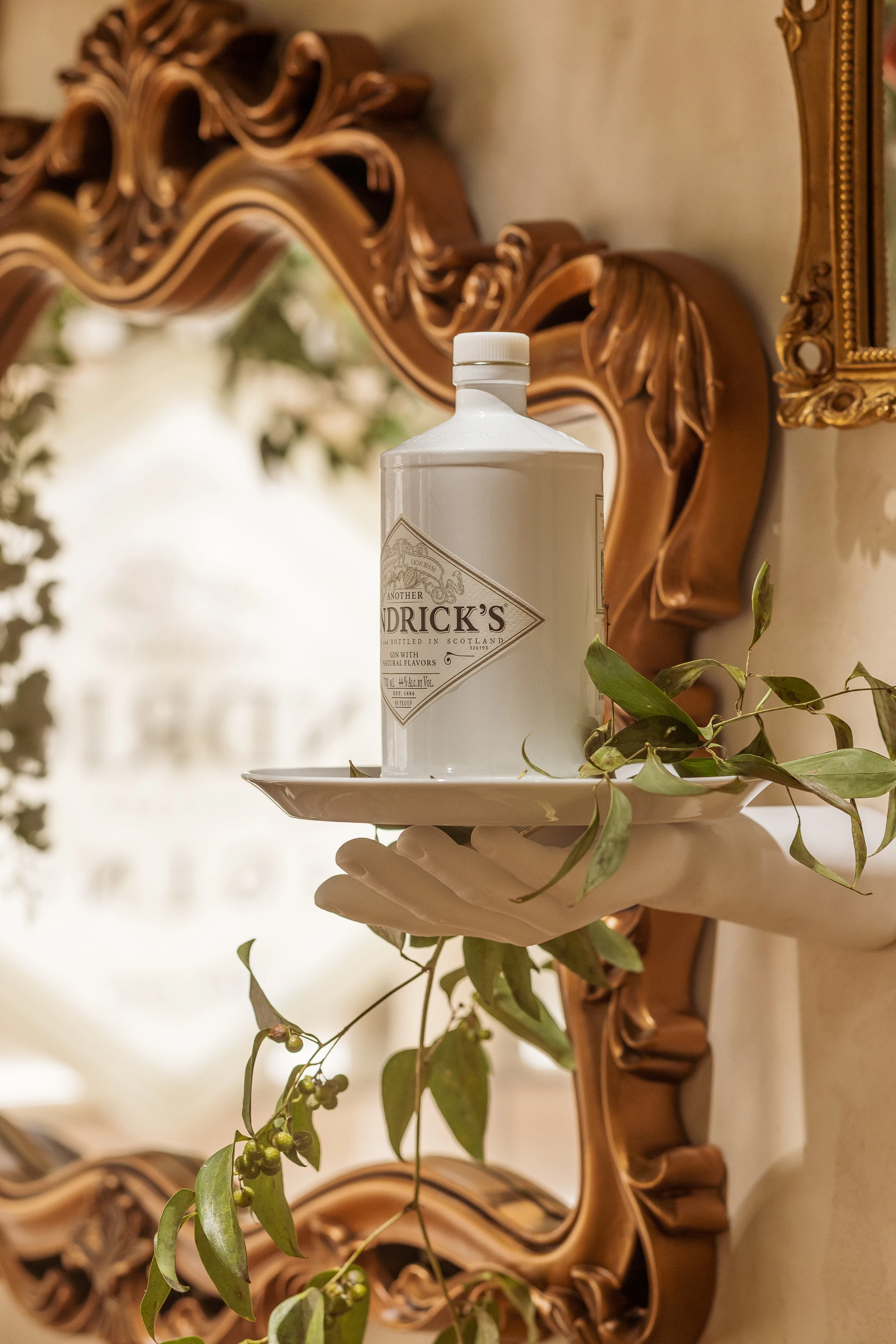 White gin bottle on tray held by fake white hand