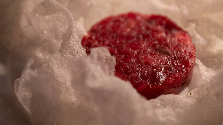 Kiekonmuotoinen tartar-pihvi valkoisen riisikakun syleilyssä