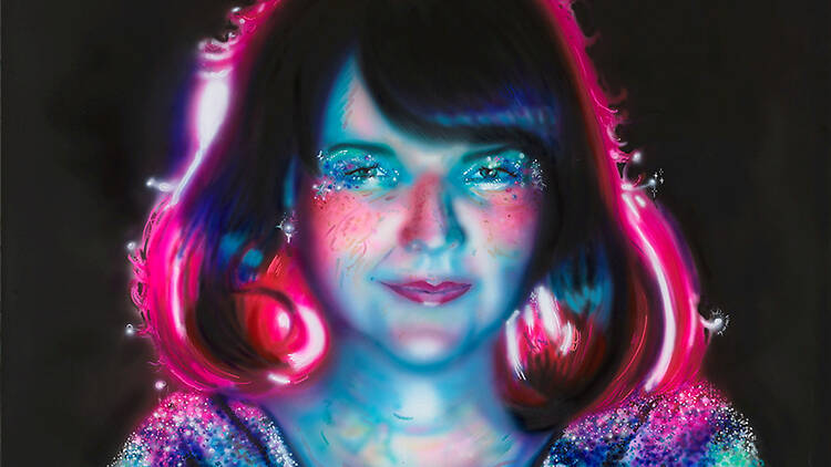 A blue and pink neon lit woman covered in glitter 