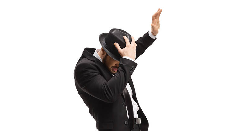 Man in a suit holding his hat isolated on white background