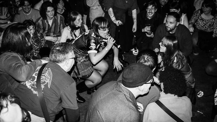 Singer crouched down in the crowd at the Old Blue Last, Shoreditch