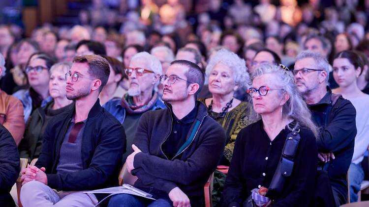 A crowd of people watching a panel