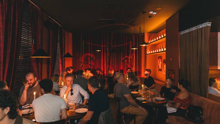 A low-lit restaurant full of people 