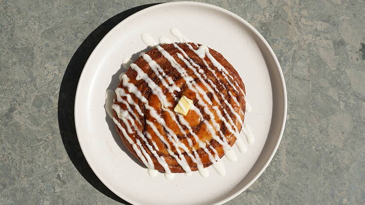 Cinnamon swirl with pad of butter and icing on plate Cinnamon swirl with pad of butter and icing on plate