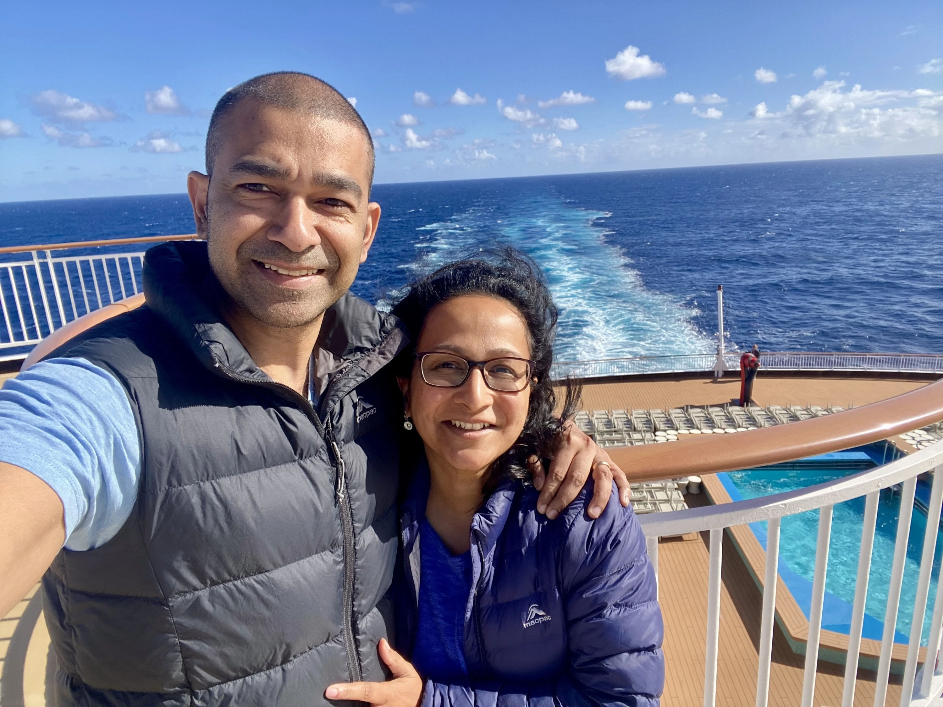 A couple standing on a cruise ship out at sea