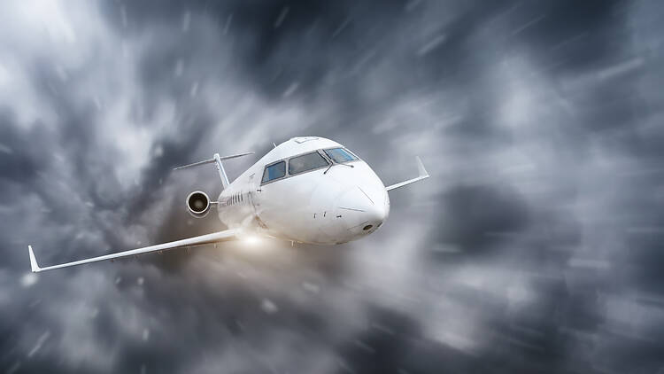 The plane flies during a storm and heavy rain overcast