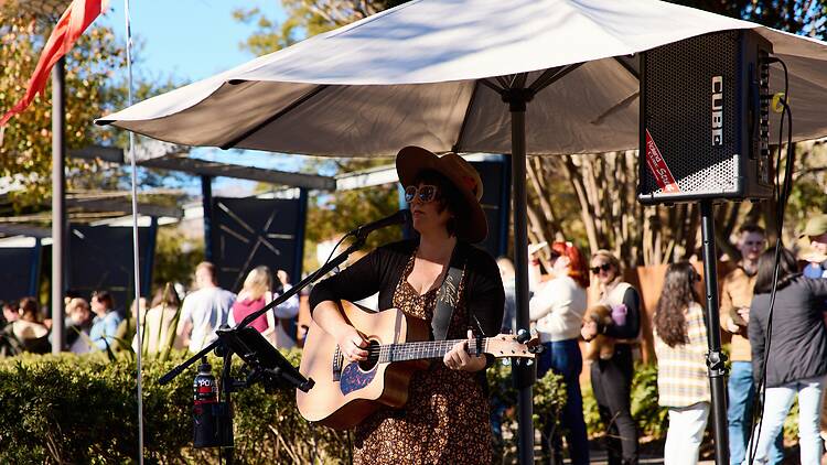A woman performing outdoors to a crowd