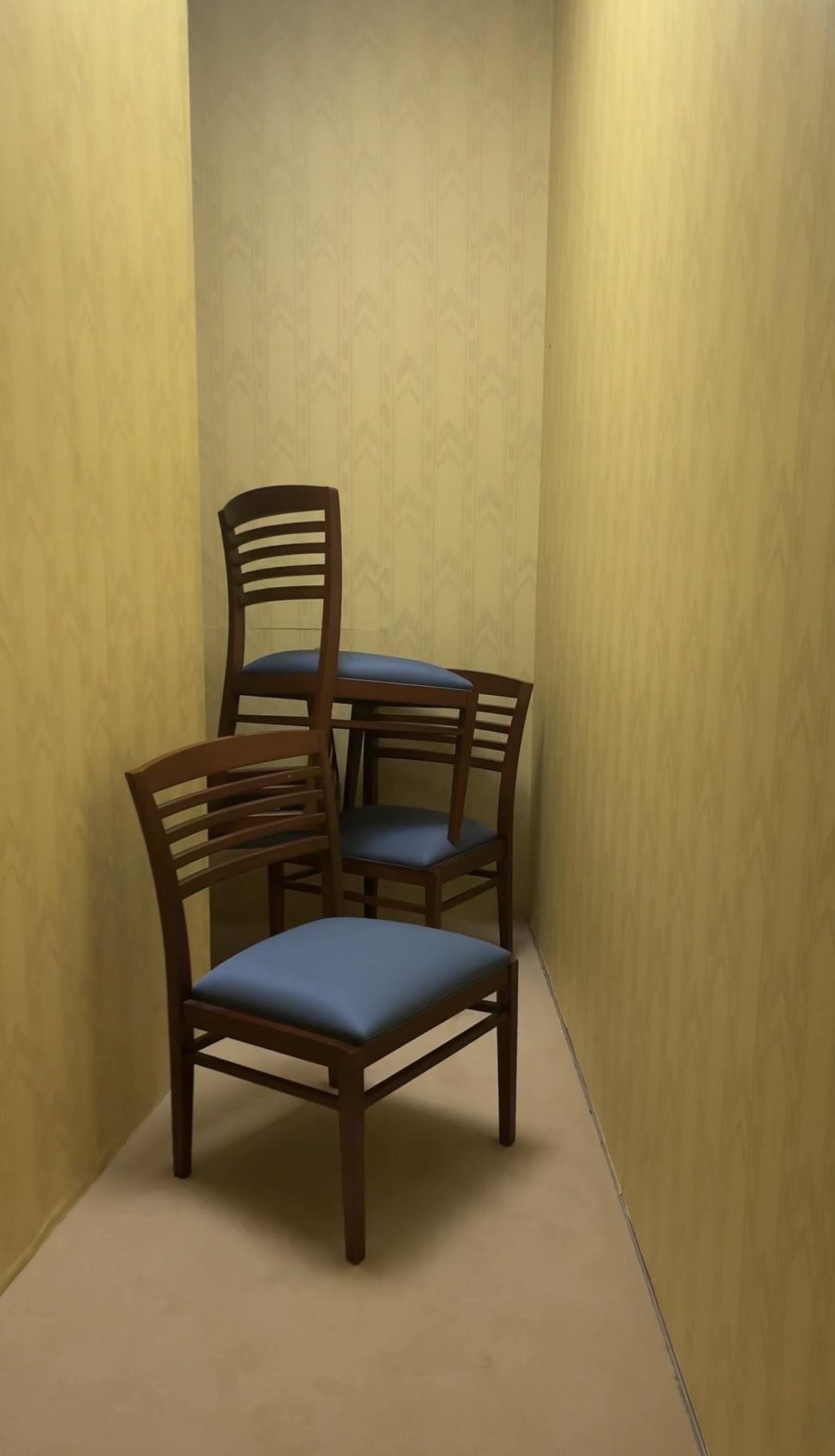 Chairs piled up in a narrow yellow hallway.