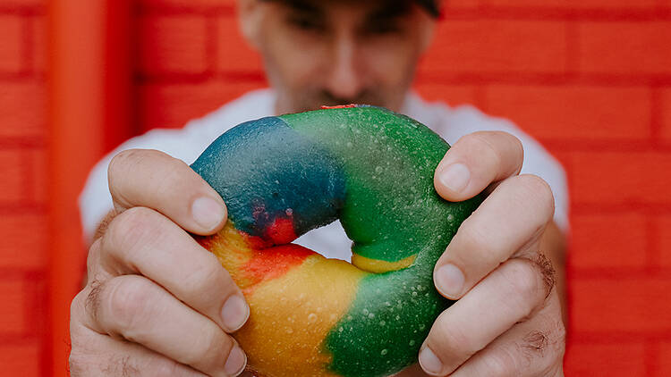 Michael Shafran of Brooklyn Boy Bagels holds a multi-coloured bagel