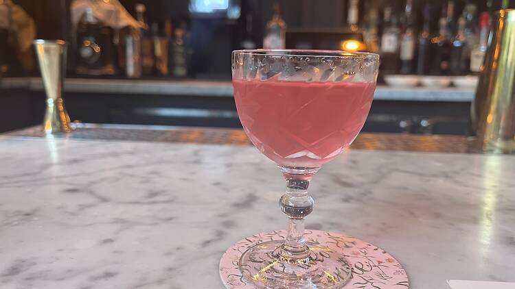 A pink cocktail in a coupe glass