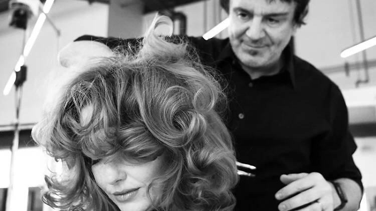Nick Arrojo styling a woman's hair.