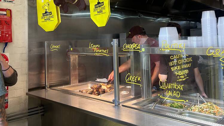 A stainless steel takeway charcoal chicken and salad counter.