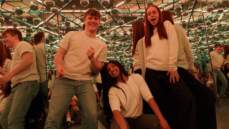 A man and two woman try out the infinity room at the Museum of Illusions 