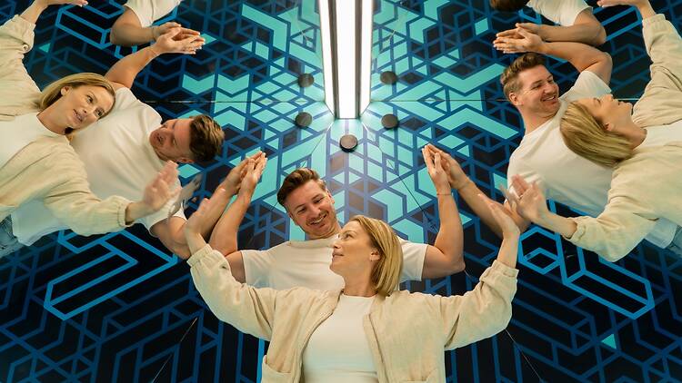 A man and two woman try out the clone room at the Museum of Illusions 