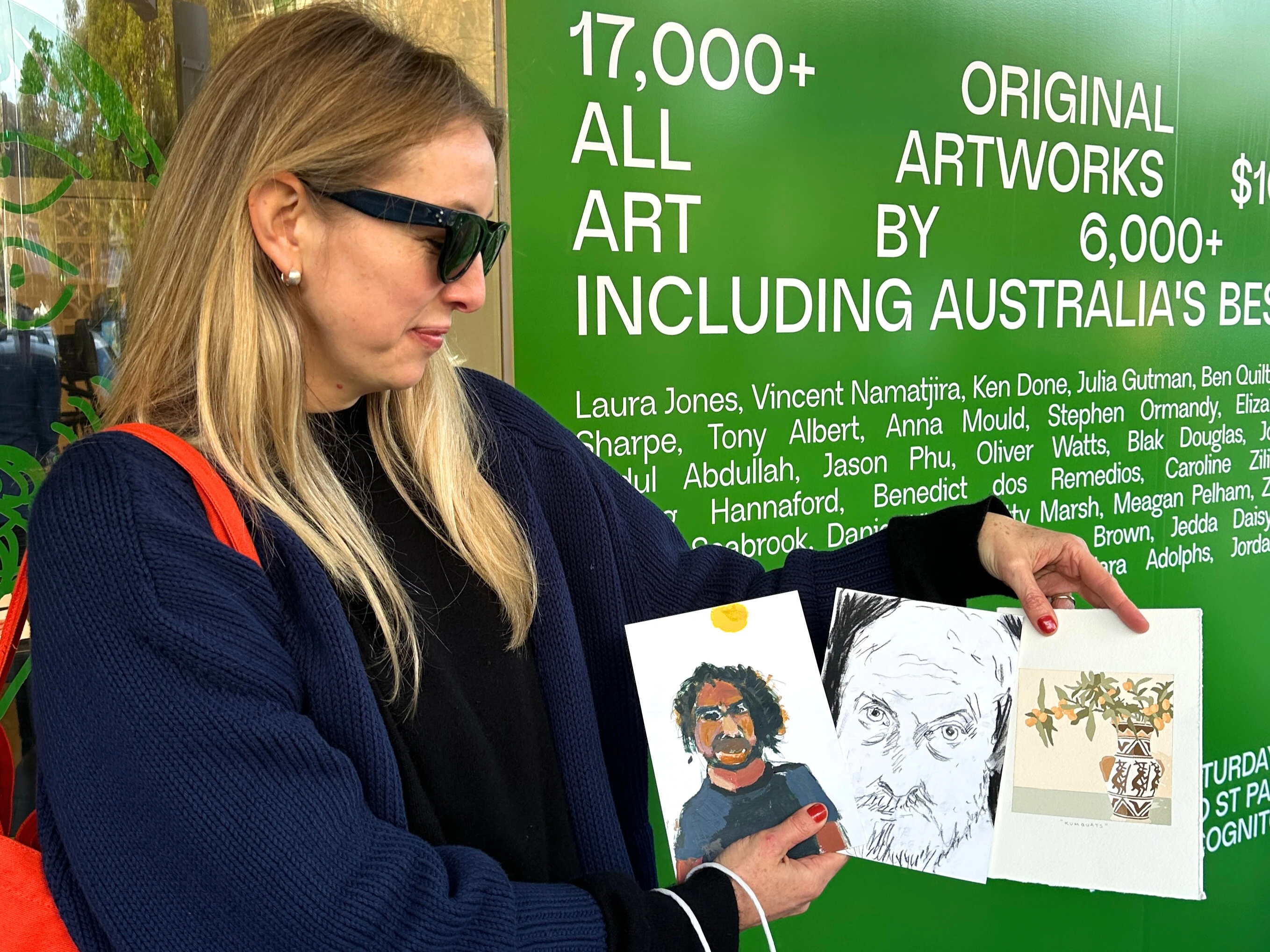 Lady holding three artworks