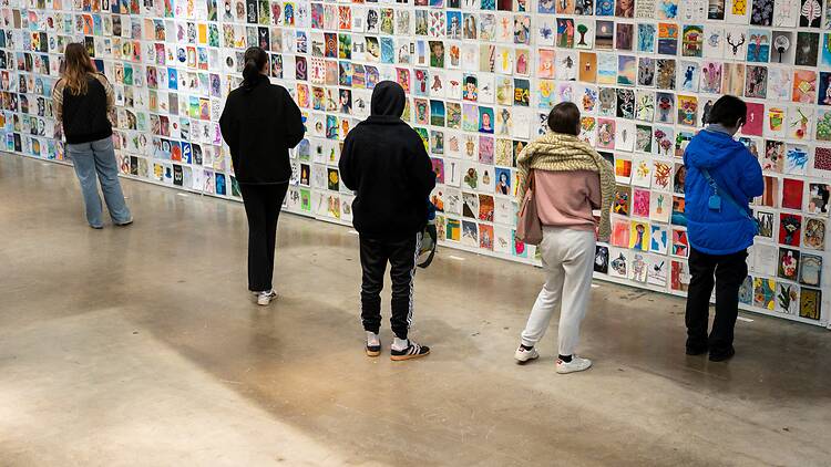 Incognito Art Show People looking at art on wall
