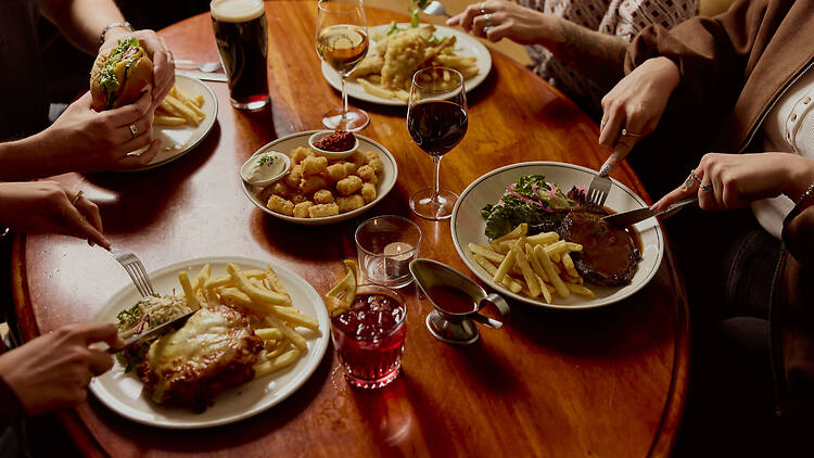 A table laden with pub food and drinks.